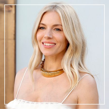 Sienna Miller wearing a white dress and gold necklace with loose waves