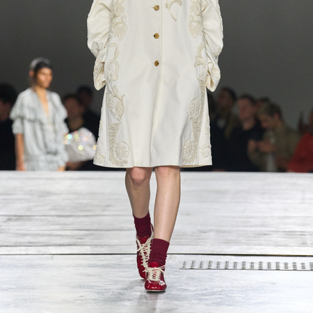 Dries Van Noten runway model wearing sleek trainers. 